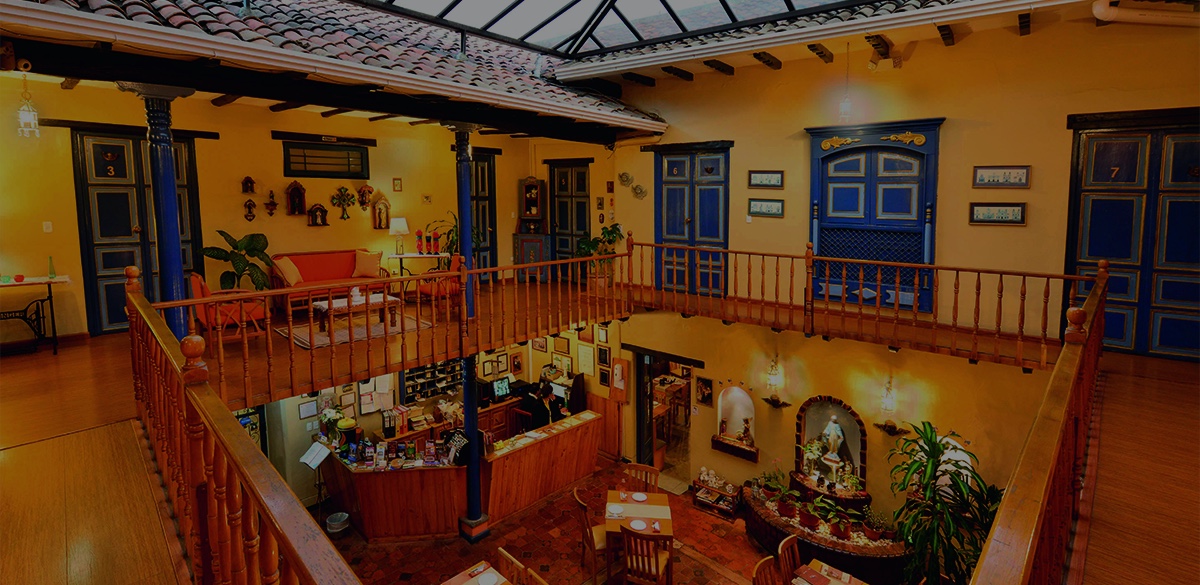 Imagen del patio interior del hotel en Ecuador, mostrando una exuberante vegetación y una arquitectura colonial encantadora, creando un ambiente sereno y acogedor para los visitantes